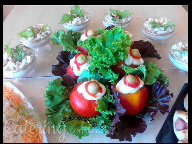 Tomates rellenos en colchón de hojas verdes y copas Waldorf